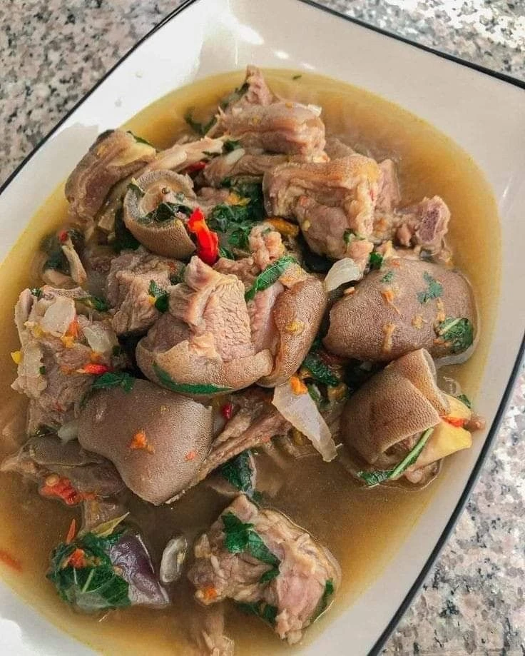 Assorted meat pepper soup with herbs in a white bowl